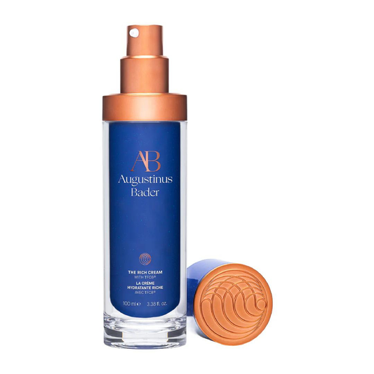 Augustinus Bader The Rich Cream — cobalt blue bottle with copper pump dispenser, shown upright on a white surface.